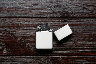 Gray metallic cigarette lighter on wooden table, top view
