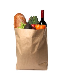 Paper bag with fresh vegetables, bread and bottle of wine on white background