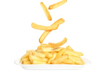 Tasty French fries falling onto plate on white background