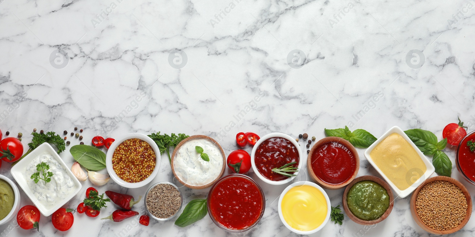 Photo of Flat lay composition with different sauces and space for text on marble background