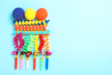 Different clown's accessories on light blue background, flat lay. Space for text
