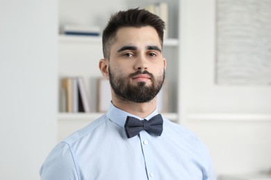 Photo of Portrait of handsome man in shirt and bow tie indoors