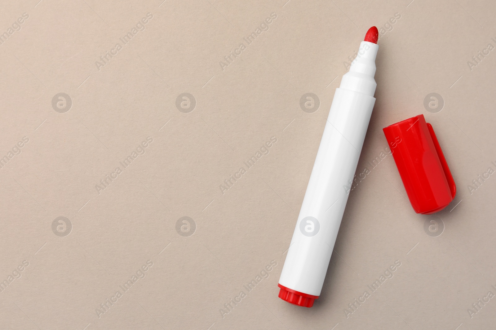 Photo of Bright red marker on beige background, flat lay. Space for text