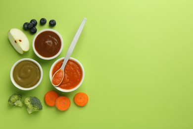 Photo of Bowls with healthy baby food, vegetables, fruits and spoon on light green background, flat lay. Space for text