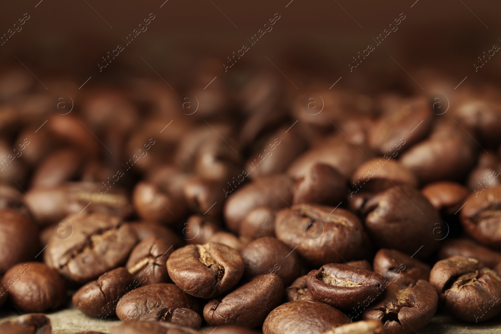 Photo of Heap of aromatic roasted coffee beans, closeup