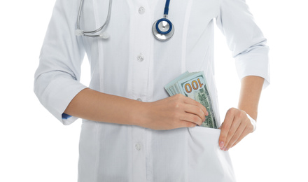 Photo of Doctor putting bribe into pocket on white background, closeup. Corruption in medicine