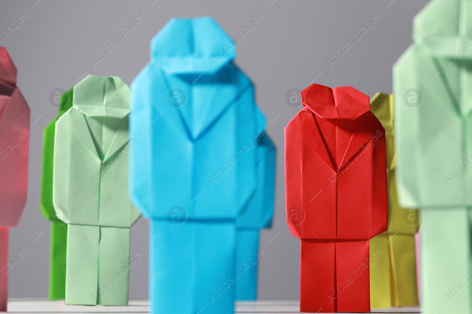 Photo of Many colorful paper figures on table, closeup. Recruiter searching employee