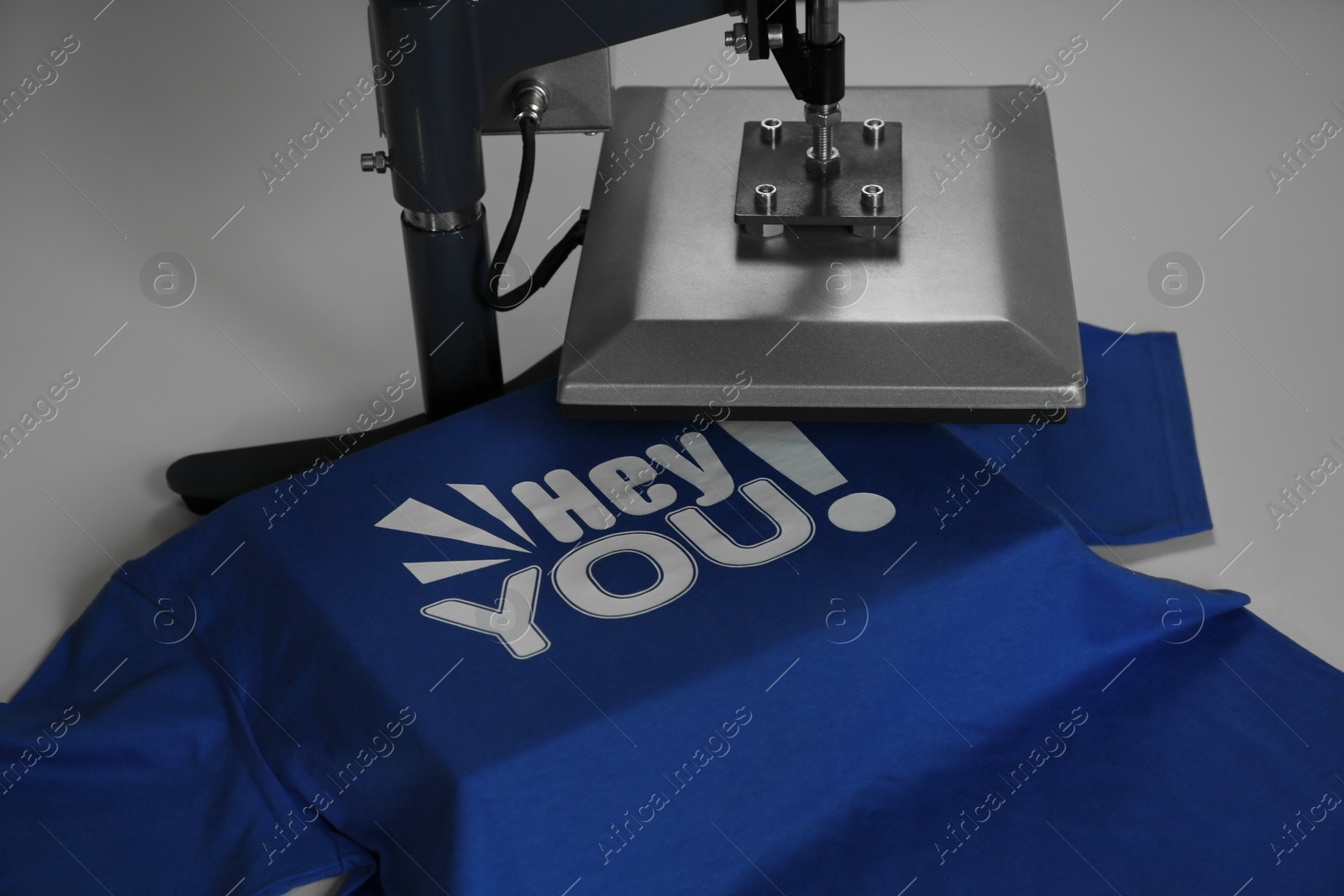 Photo of Printing logo. Heat press with t-shirt on white table, closeup