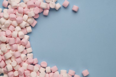 Delicious marshmallows on light blue background, flat lay. Space for text