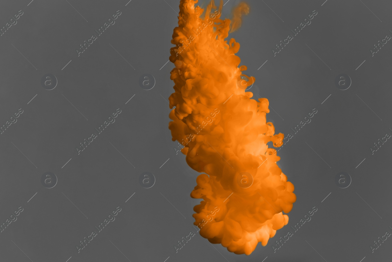 Photo of Splash of orange ink on grey background