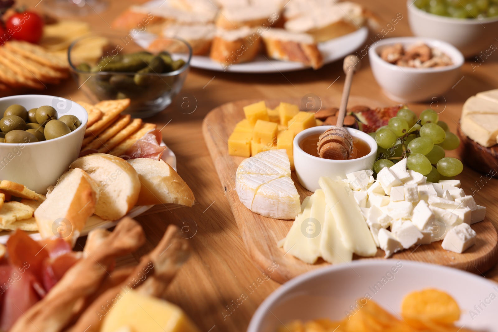 Photo of Assorted appetizers served on wooden table, closeup