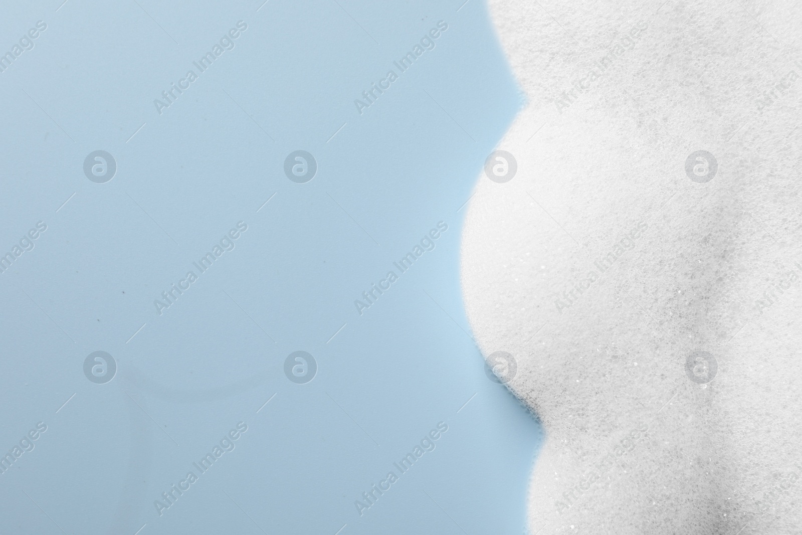 Photo of Foam sample on light blue background, top view. Space for text