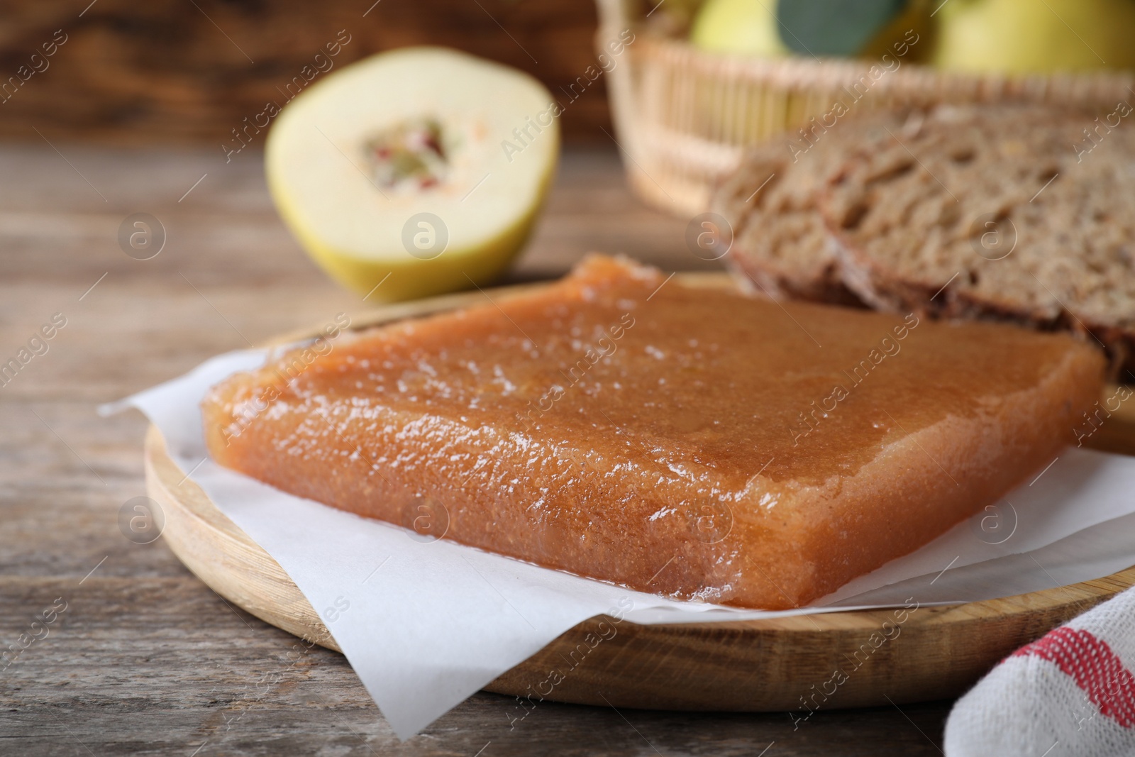 Photo of Delicious quince paste on wooden table, closeup