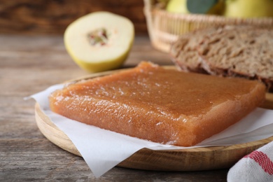 Photo of Delicious quince paste on wooden table, closeup