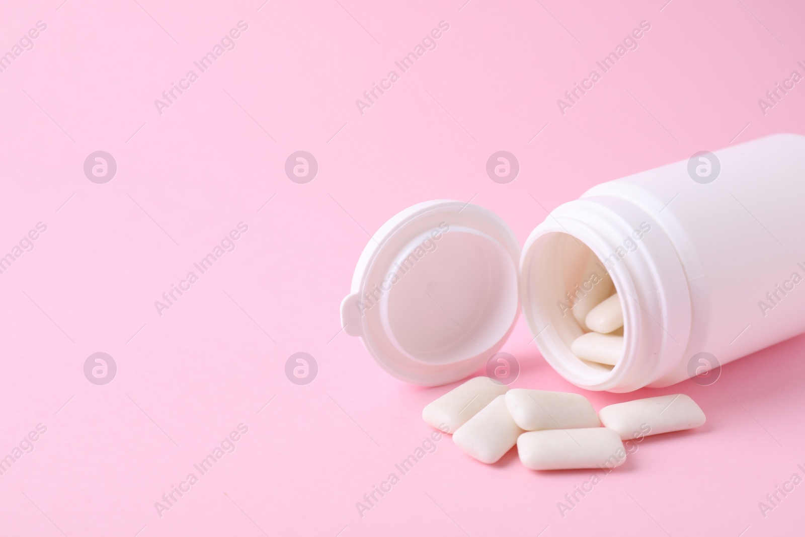 Photo of Jar with chewing gums on pink background, closeup. Space for text