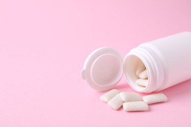 Photo of Jar with chewing gums on pink background, closeup. Space for text