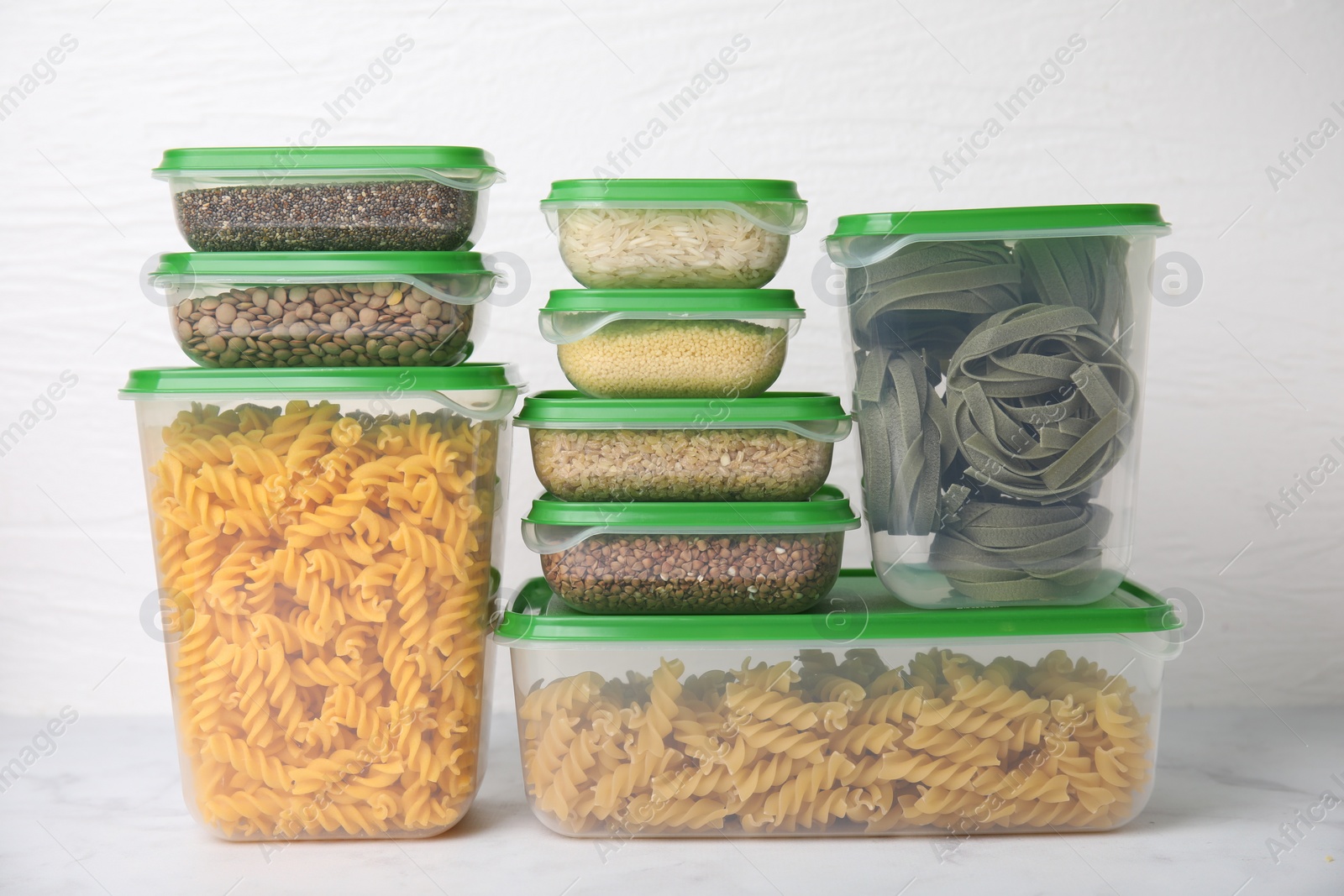 Photo of Plastic containers filled with food products on white table