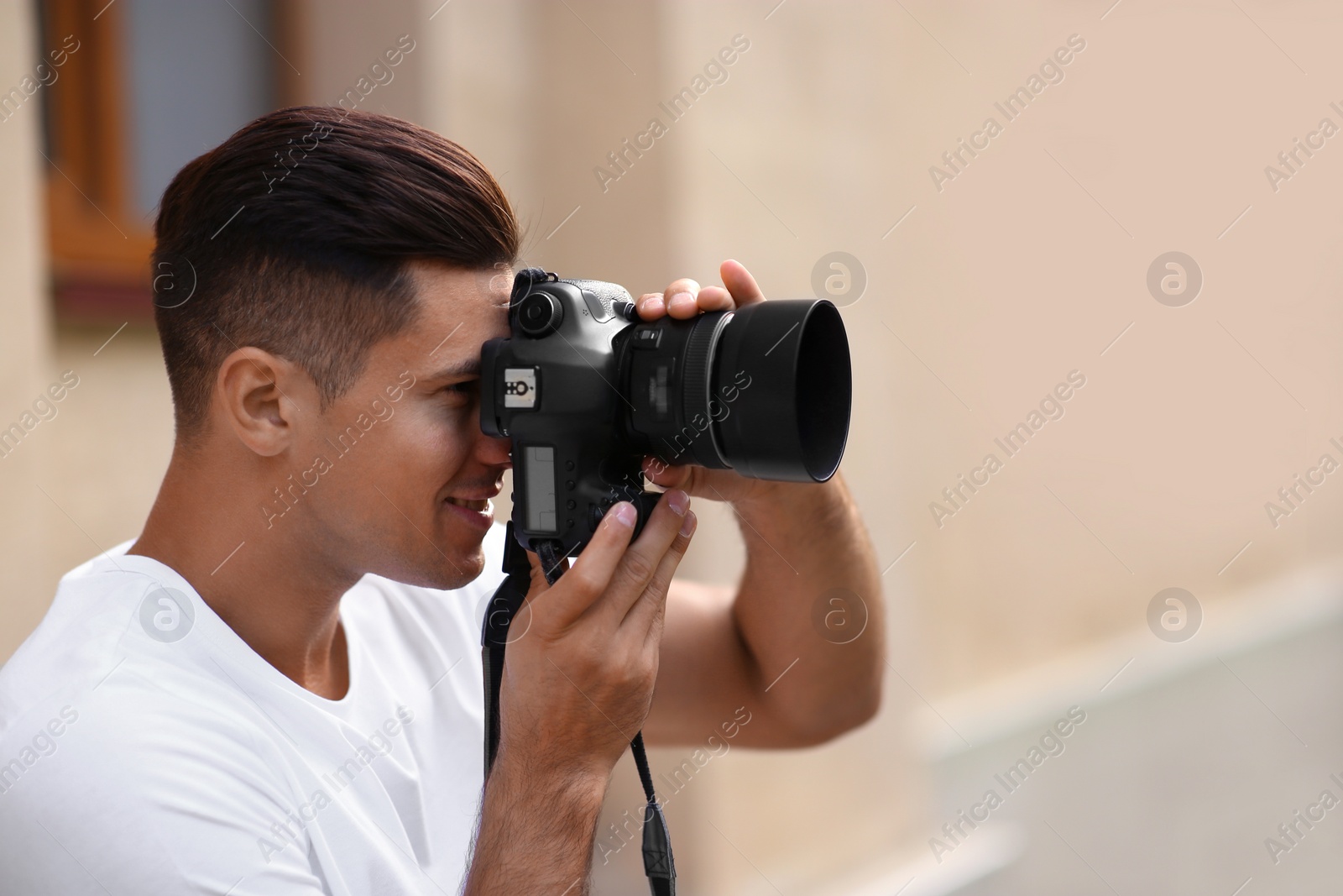 Photo of Photographer taking picture with professional camera on city street