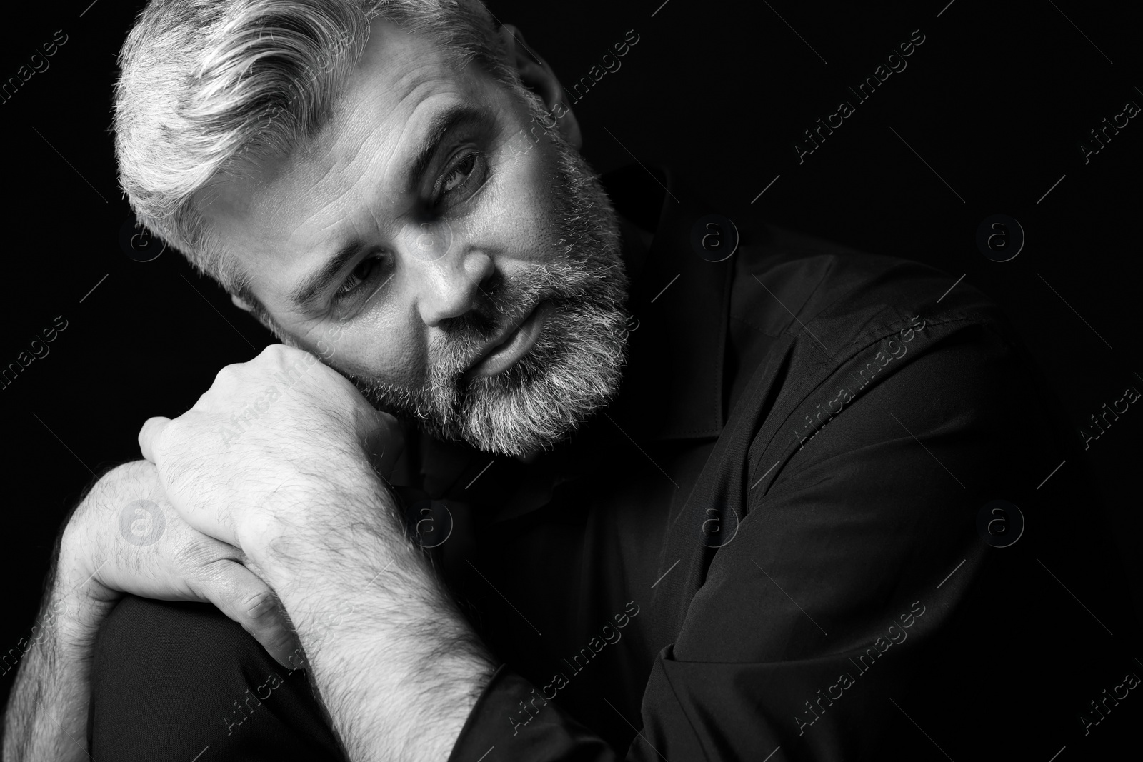 Photo of Portrait of handsome man on dark background. Black and white effect