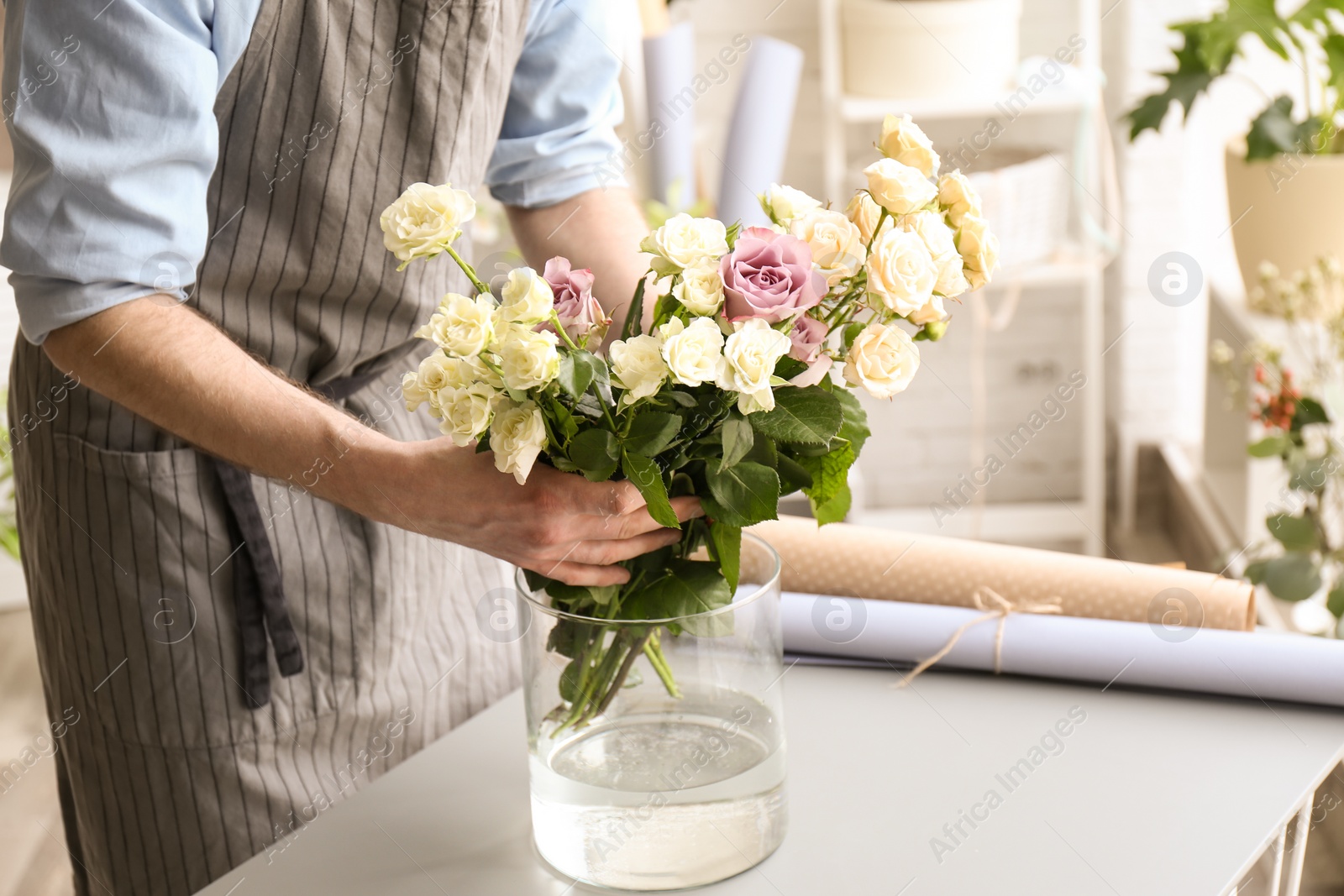 Photo of Male florist creating floral composition at workplace