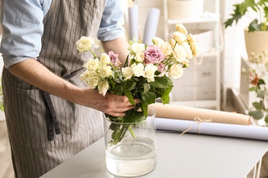 Male florist creating floral composition at workplace