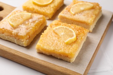 Tasty lemon bars on white table, closeup