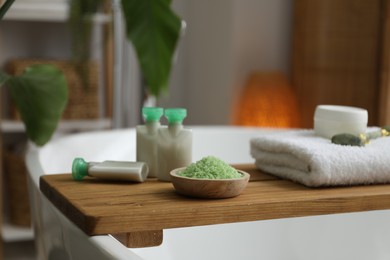 Wooden tray with spa products on bath tub in bathroom