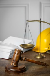 Labour, construction and land law concepts. Judge gavel, scales of justice, open book with hardhat on wooden table