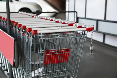 Photo of Row of empty metal shopping carts near supermarket outdoors