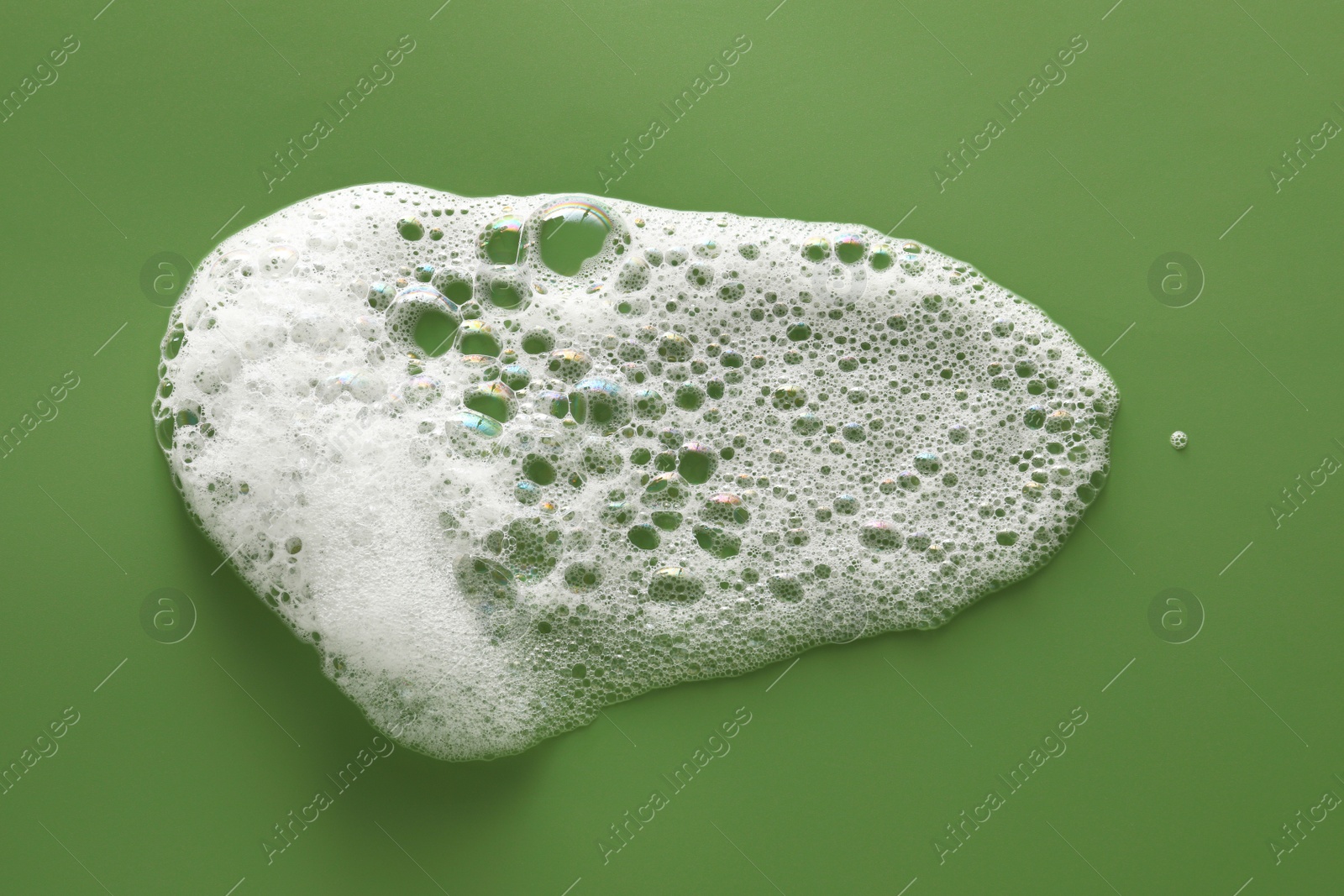 Photo of Smudge of white washing foam on olive background, top view