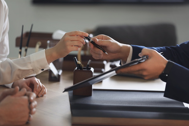 Male lawyer working with clients in office, closeup