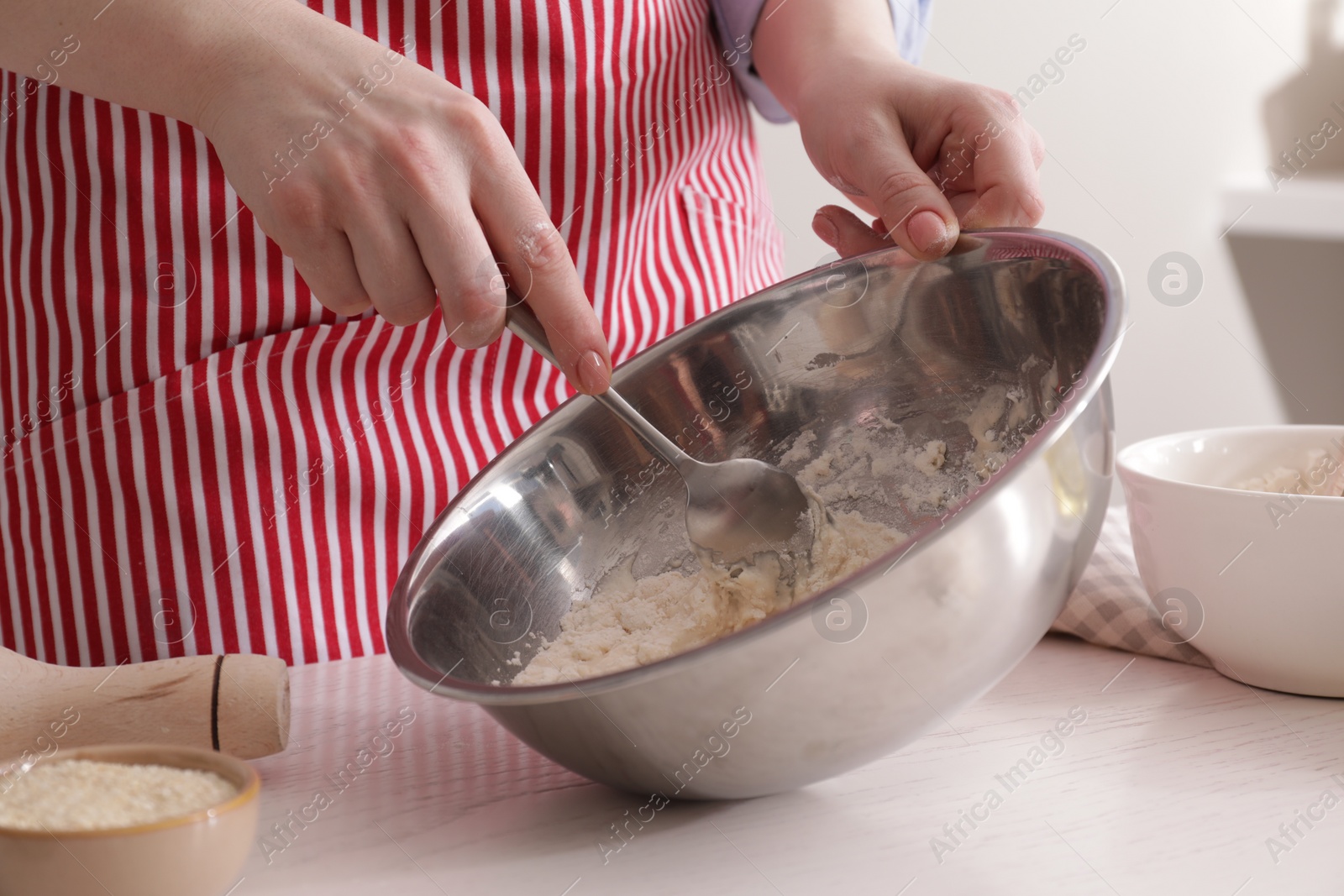 Photo of Woman making traditional grissini at white wooden table indoors, closeup