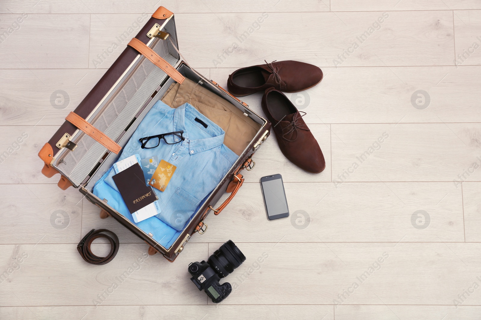 Photo of Packed suitcase on wooden background, top view. Space for text