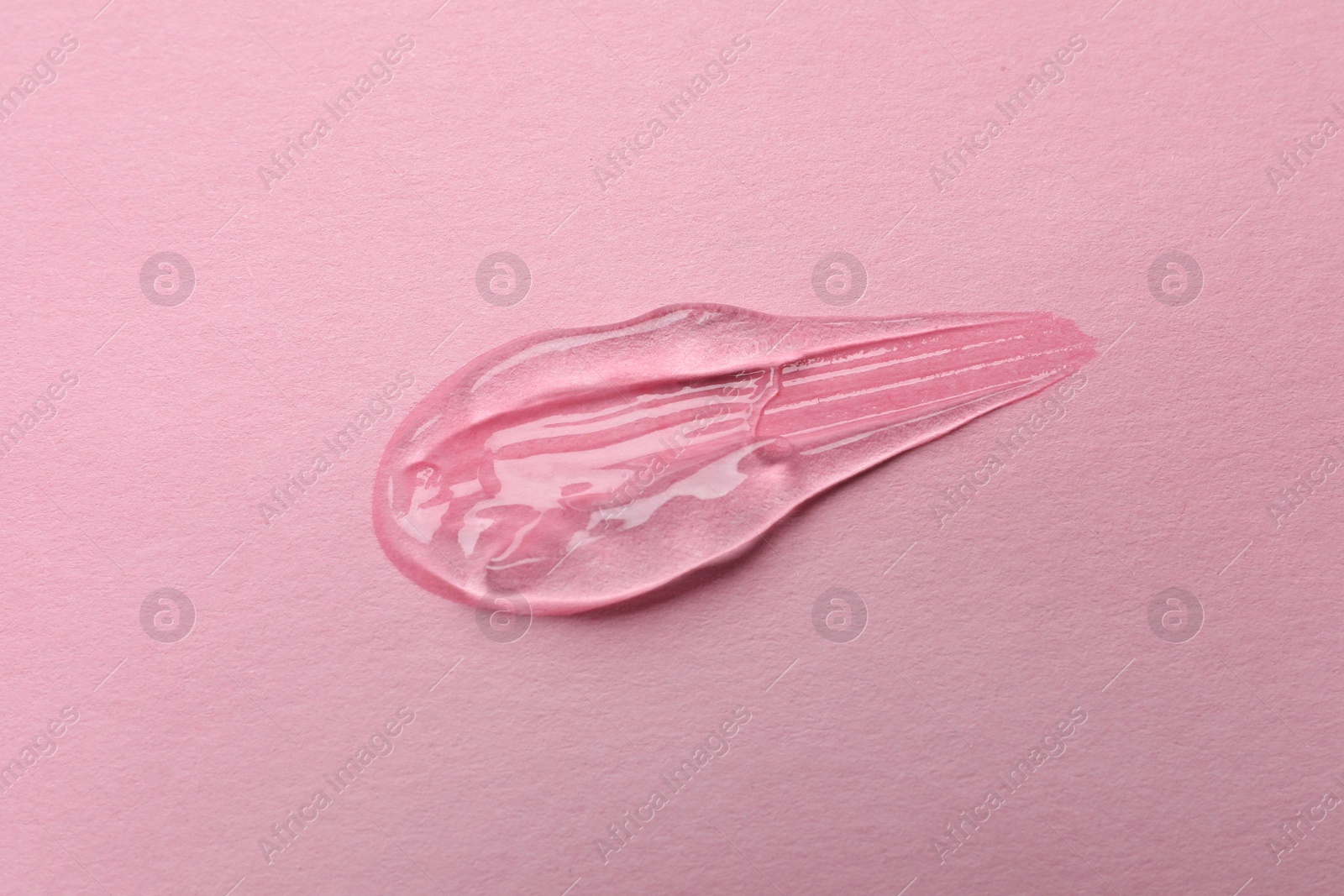 Photo of Sample of transparent gel on pink background, top view