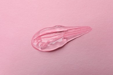 Sample of transparent gel on pink background, top view