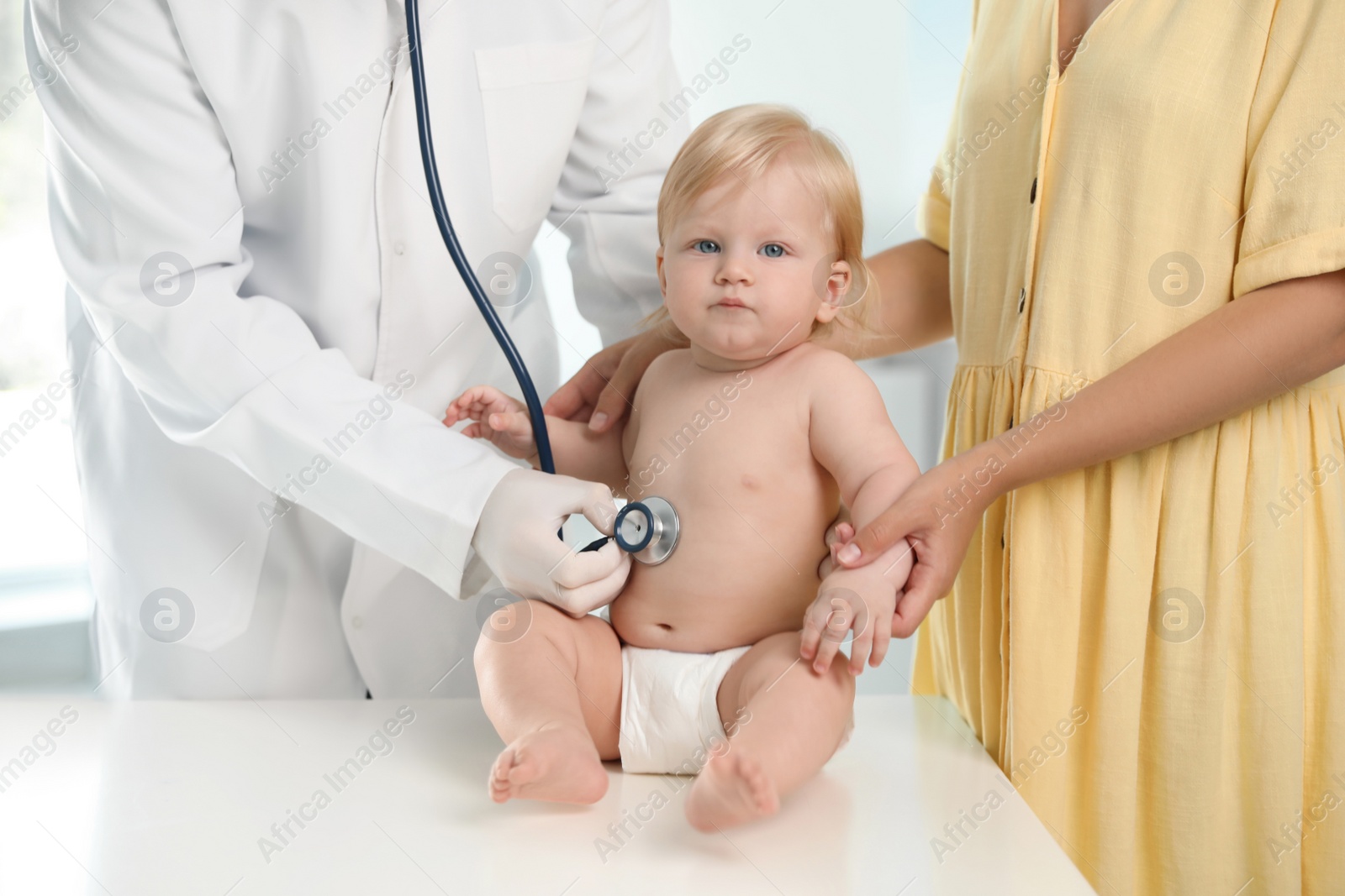 Photo of Pediatrician examining baby with stethoscope in hospital. Health care