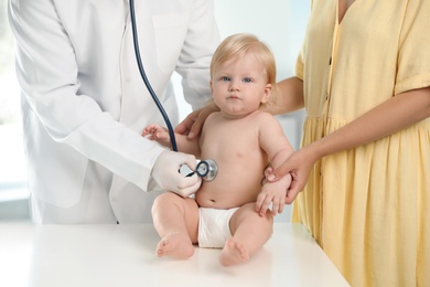 Photo of Pediatrician examining baby with stethoscope in hospital. Health care