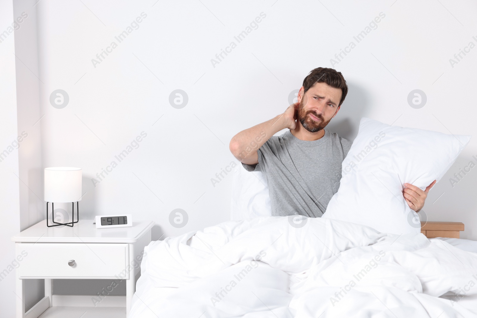 Photo of Man with soft pillow on bed at home