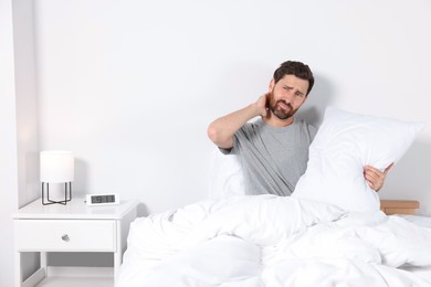 Photo of Man with soft pillow on bed at home