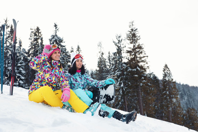 Friends with equipment on snowy hill. Winter vacation