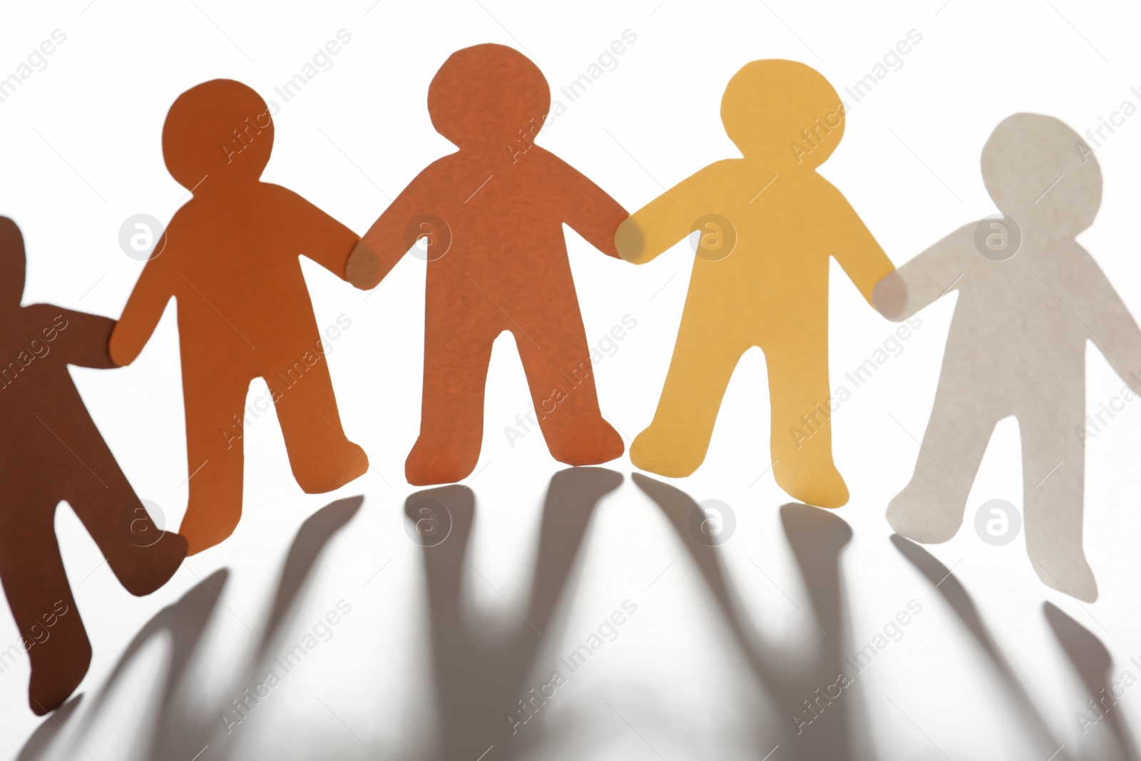 Photo of Paper people holding hands on light background. Unity concept