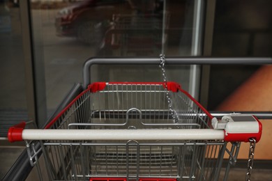 Photo of New empty metal shopping cart outdoors, closeup