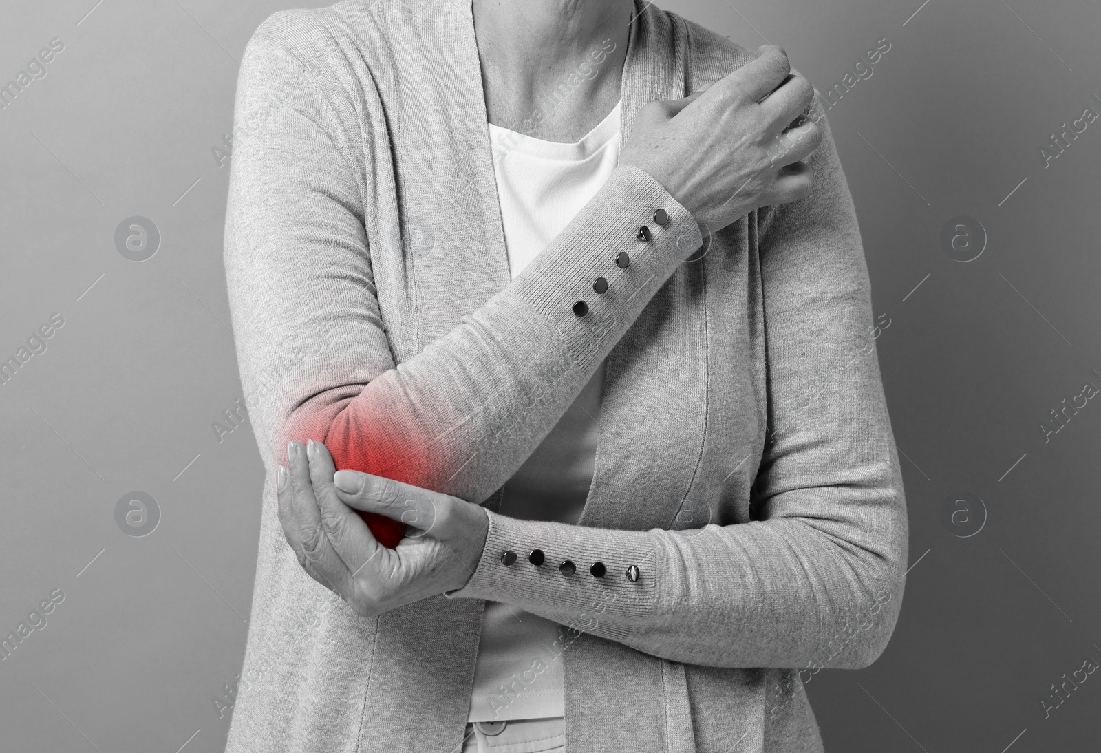 Image of Woman suffering from pain in elbow, closeup. Black and white effect