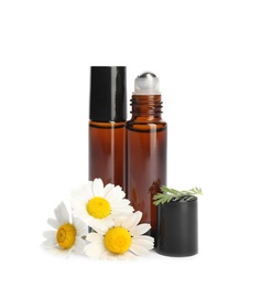 Photo of Chamomile flowers and cosmetic bottles of essential oil on white background