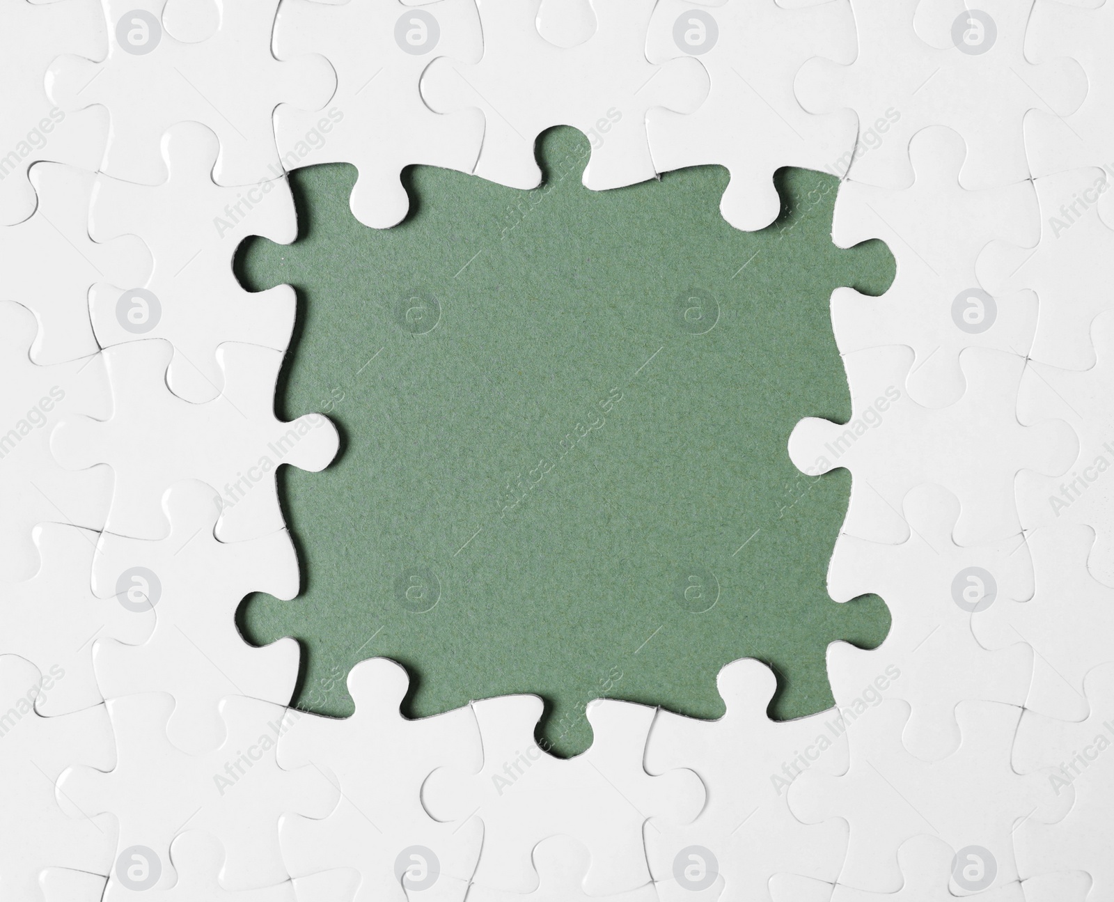 Photo of Frame made with white puzzle pieces on grey background, top view. Space for text