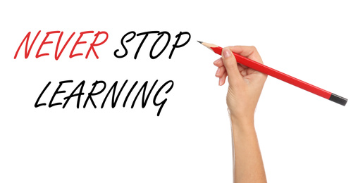 Image of Woman writing phrase NEVER STOP LEARNING on white background, closeup. Banner design