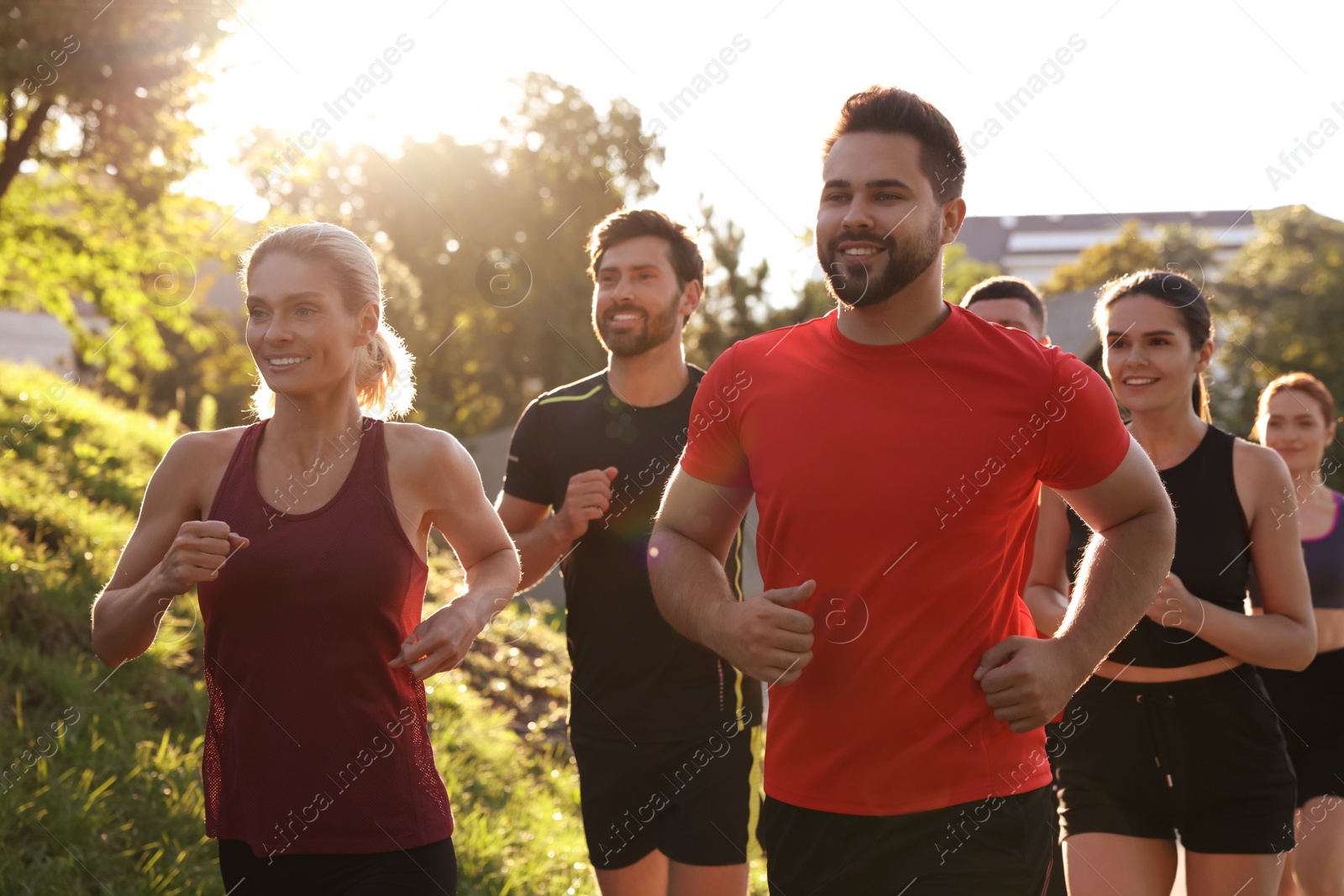 Photo of Group of people running outdoors on sunny day