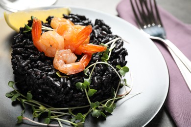 Delicious black risotto with shrimps on table, closeup