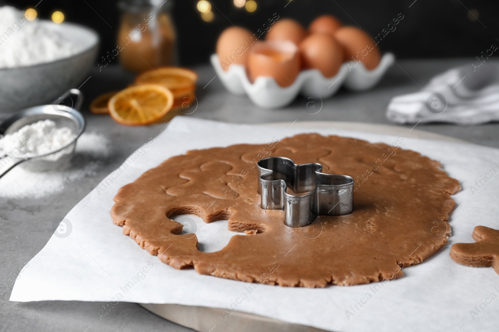 Photo of Making homemade Christmas cookies. Dough for gingerbread man and cutter on light grey table