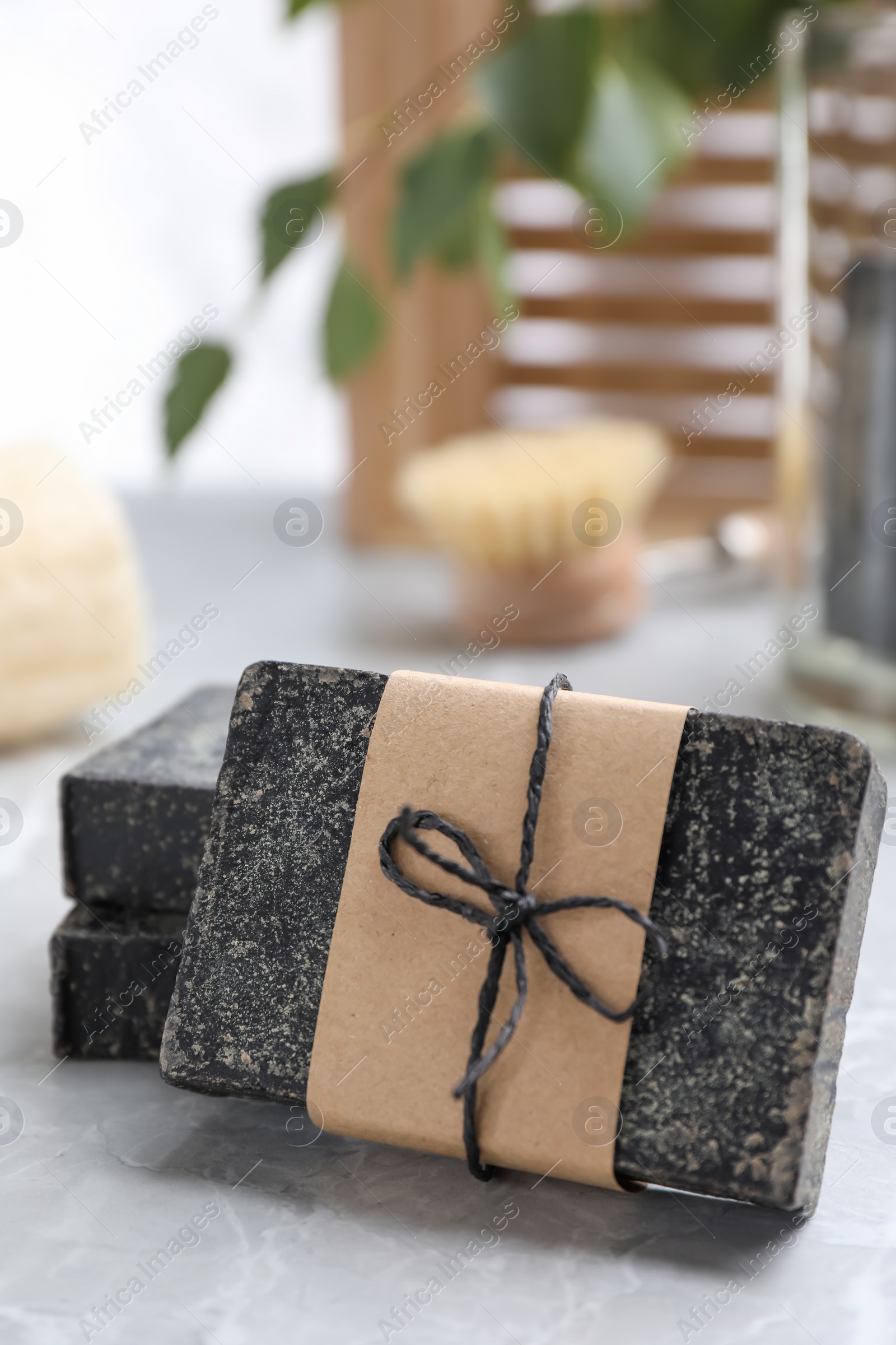 Photo of Natural tar soap on light grey table, closeup